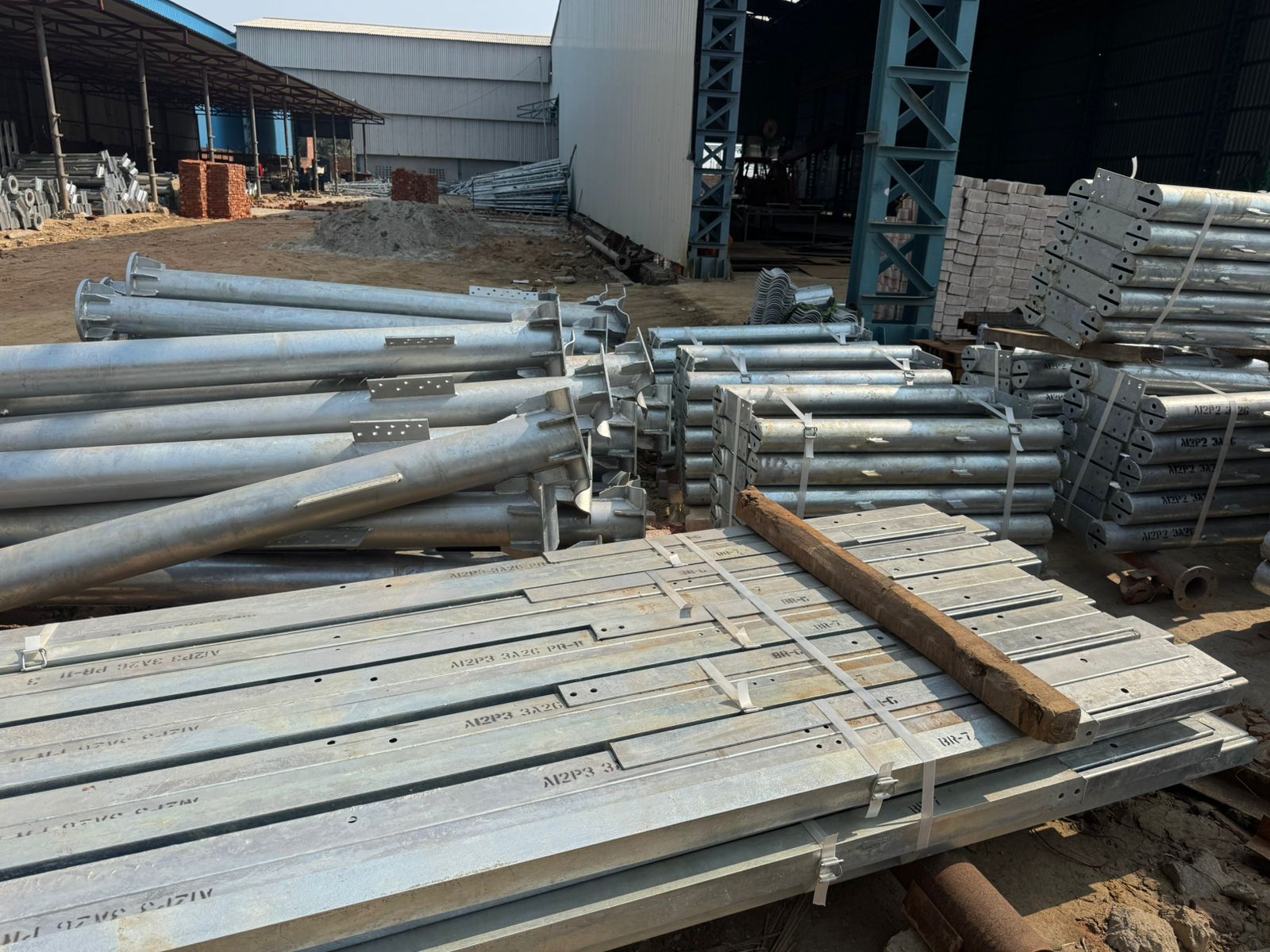 Galvanized telecom pole assemblies stored in the yard